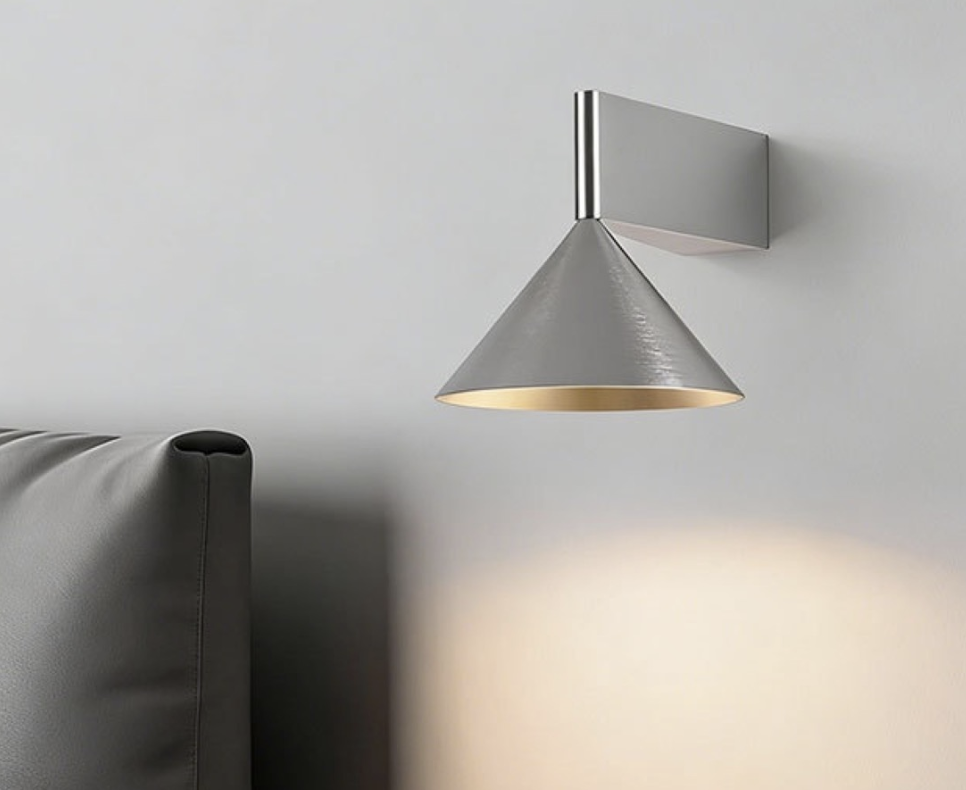 Modern wall light casting a warm glow beside a sofa