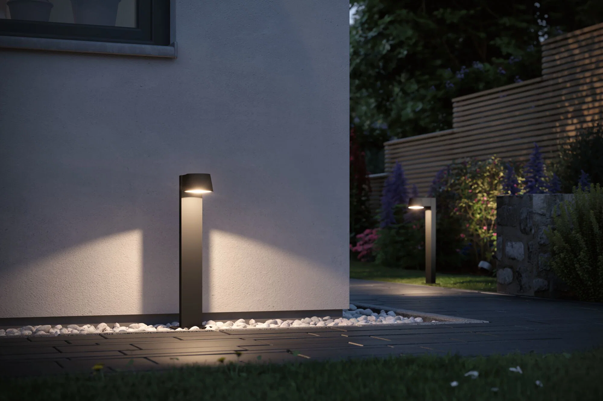 Illuminated bollard lights spaced along a modern garden path